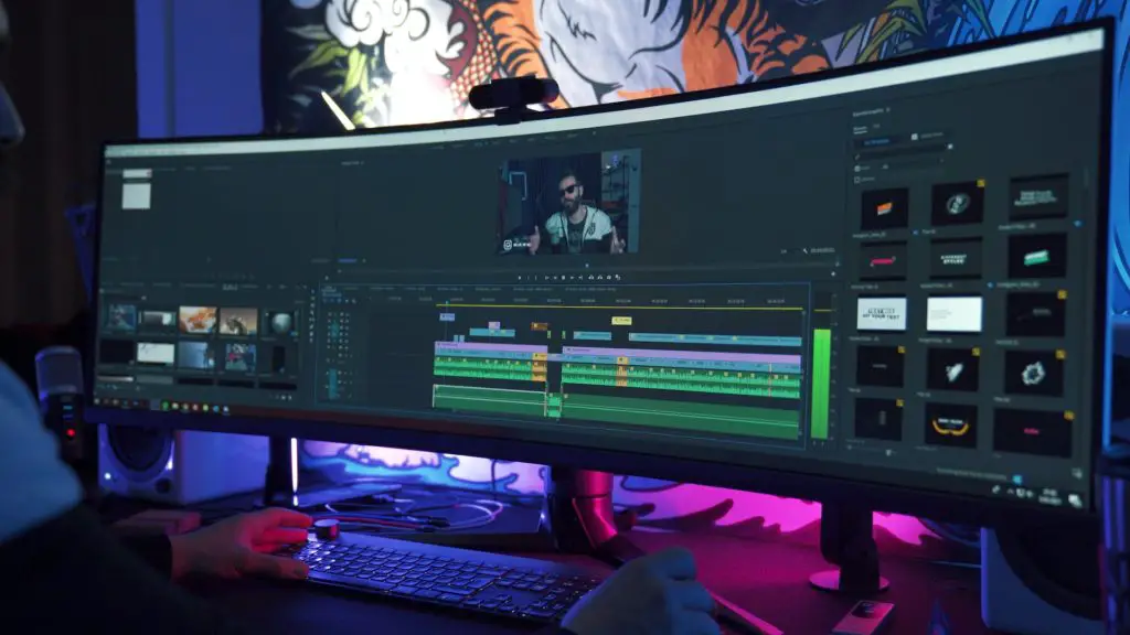 video content creator, editing video on a large monitor