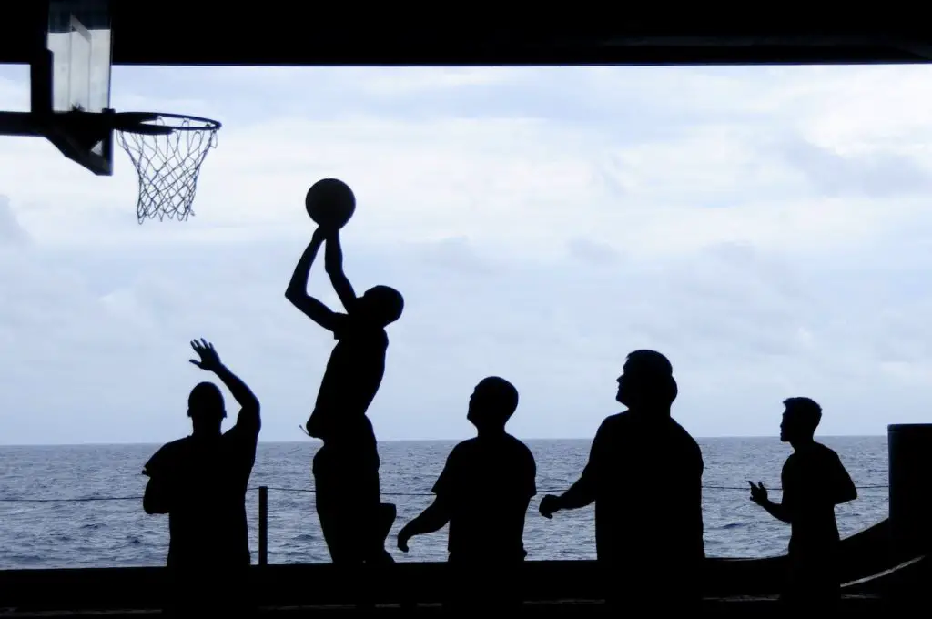 silhouette of people playing basketballl
